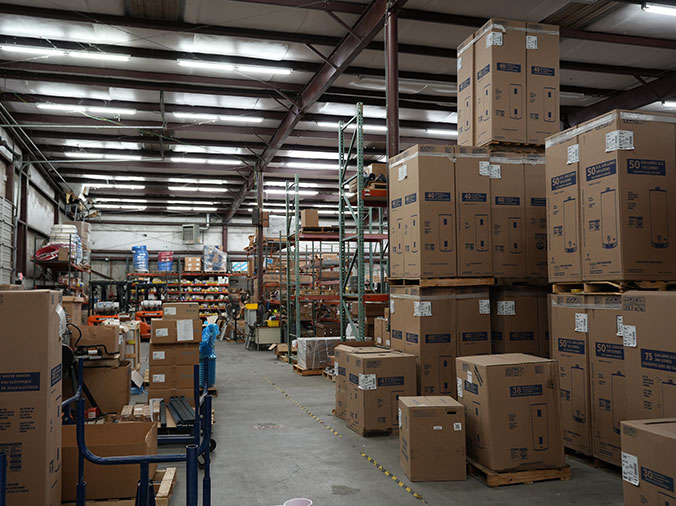 Boxed warter heaters and other plumbing supplies in warehouse